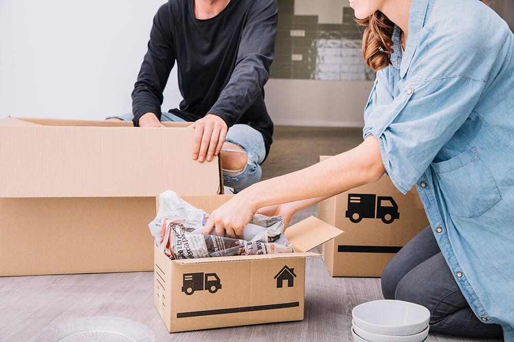 Мужчина и женщина упаковывают вещи в коробки